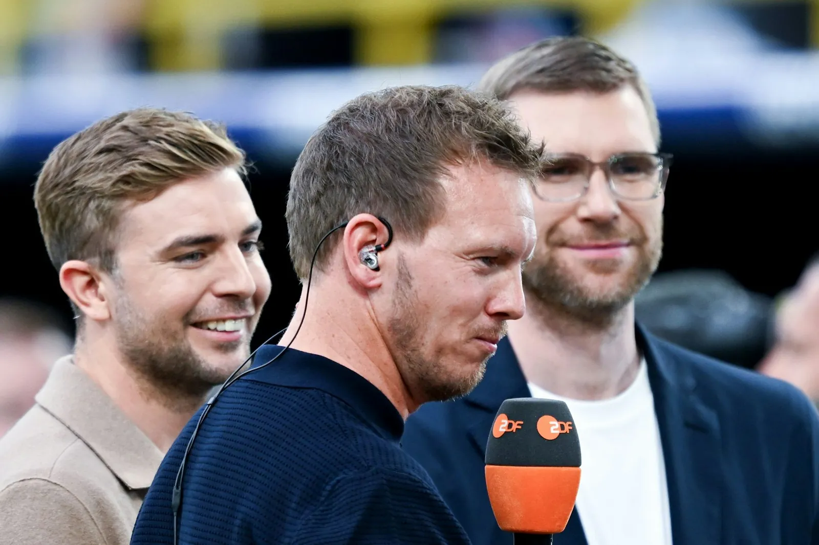Da waren alle noch zufrieden: Ex-Bundestrainer Julian Nagelsmann im ZDF-Interview bei der EM 2024, im Hintergrund Christoph Kramer (l.) und Mertesacker (r.).